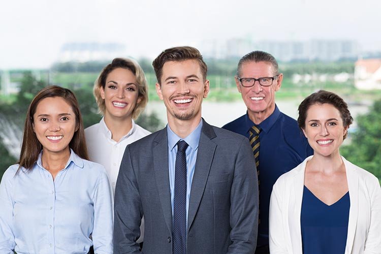 Portrait of happy young business leader standing with his successful team. They smiling at camera. Business team concept